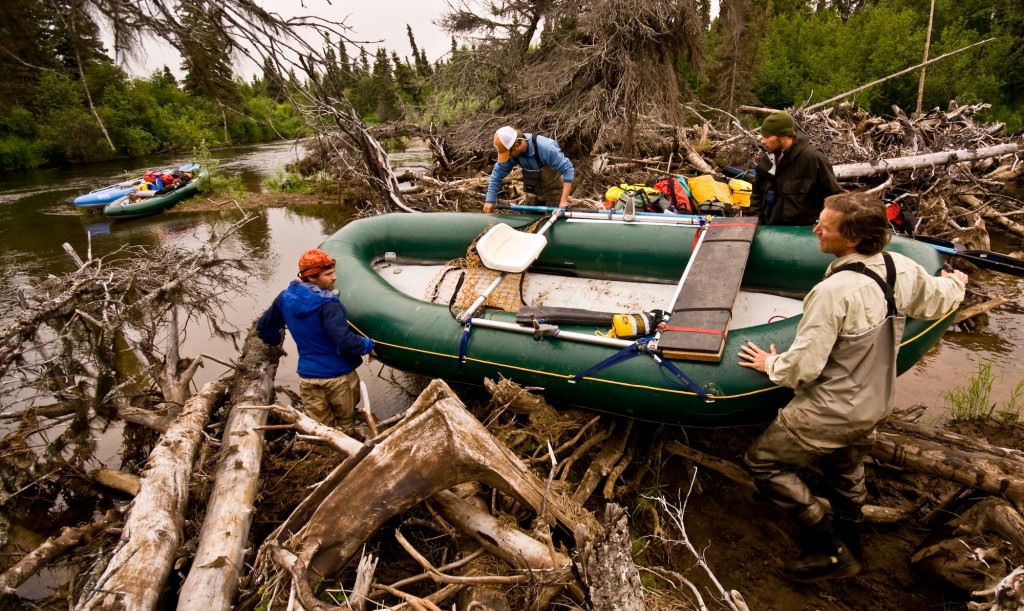 Boys portage raft through log jam